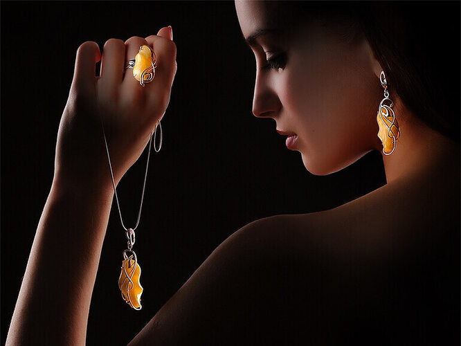 женщина держит в руках прозрачный янтарь